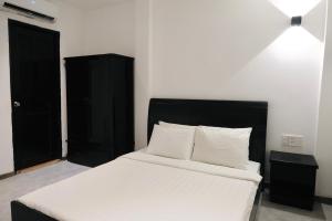 胡志明市Nicecy Hotel - Yersin Street的一间卧室配有一张床和一个黑色橱柜