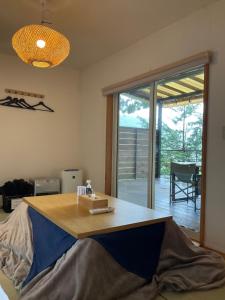 富士河口湖Retreat Camp Mahoroba的客房设有木桌,享有庭院的景色