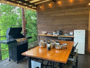 富士河口湖Retreat Camp Mahoroba的厨房配有木桌和炉灶。