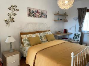 斯佩隆加Casa Mimosa Holiday Room的一间卧室配有一张带黄床单和吊灯的床。