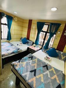 香港Philippine Hostel的配有蓝色窗帘的客房内的两张床