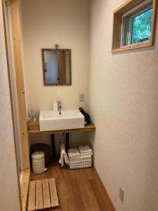 富士河口湖Retreat Camp Mahoroba的一间带水槽和镜子的浴室