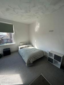 LincolnshireSkegness Town Centre Apartment 1的一间卧室配有一张床、一张书桌和一个窗户。
