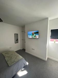 LincolnshireSkegness Town Centre Apartment 1的卧室配有一张床,墙上配有电视。