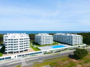 洛格沃Rogowo Pearl City Apartments的两座白色建筑和海洋的空中景观