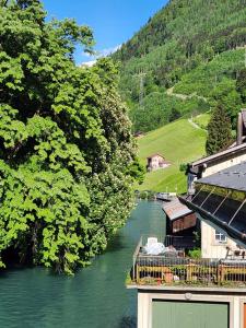 SchwändiSpacious cellar studio surrounded by mountains and lake的享有河流美景,拥有建筑和树木