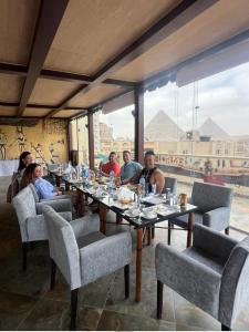 开罗King Pyramids View Hotel的一群坐在餐厅桌子上的人