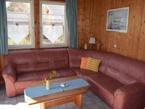 埃克斯特塔尔Komfort-Ferienhaus Wolke #56的客厅里一张棕色的皮沙发,配有桌子