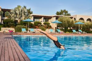 林都斯Aquagrand Exclusive Deluxe Resort Lindos - Adults only的一个人躺在游泳池里