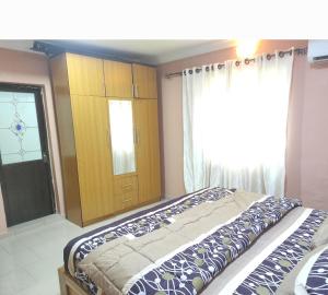 AbeokutaInviting 2-Bed House in Abeokuta的一间卧室配有床、橱柜和窗户