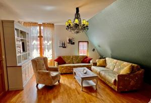 波茨坦Apartmenthaus im holländischen Viertel的客厅配有沙发、椅子和吊灯