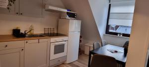 多尔马根TAKAppartement Dormagen的小厨房配有白色冰箱和桌子