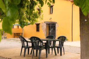 San Quintín de MedionaMasia en plena naturaleza y tranquilidad的黄色建筑前的桌椅