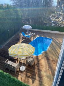 萨潘贾Sapanca Gönül Sofram Hotel & Bungalow & Villas的露台配有两把遮阳伞和椅子,