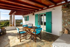 德里奥斯Villa di Sole的庭院配有木桌和蓝色椅子