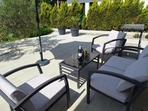 赫瓦尔Mimi的庭院配有椅子和一张带葡萄酒的桌子。
