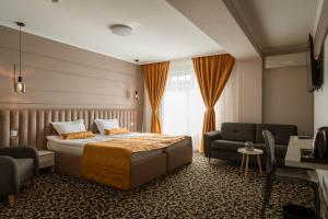 拜勒乌努麦ALLEGRIA HOTEL Spa的一间卧室配有一张床、一张沙发和一把椅子