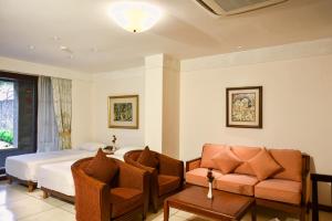 库塔The Patra Bali Resort & Villas - CHSE Certified的酒店客房,配有床和沙发