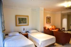 库塔The Patra Bali Resort & Villas - CHSE Certified的酒店客房,设有两张床和一张沙发