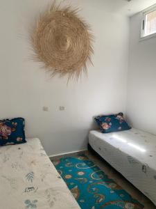 沃利迪耶Dar Sultan Oualidia的一间设有两张床的客房,墙上有花圈