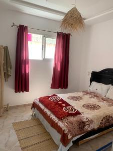 沃利迪耶Dar Sultan Oualidia的一间卧室配有红色窗帘的床