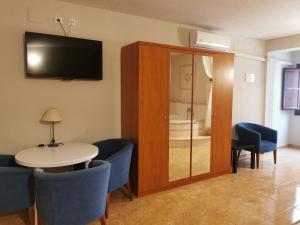 比纳罗斯Hotel Castellverd的配有桌椅和电视的客房