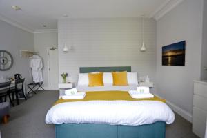 埃克斯茅斯埃克斯茅斯海豚酒店的一间卧室配有一张带黄色枕头的大床