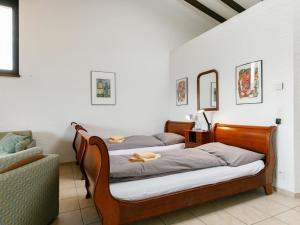 皮亚佐尼亚Apartment Miralago - Utoring-21 by Interhome的一张沙发和镜子的客房内的两张床