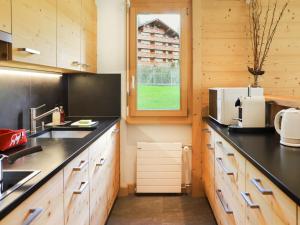威拉尔-苏-罗伦Apartment Diamant 6 by Interhome的厨房配有木制橱柜和黑色台面