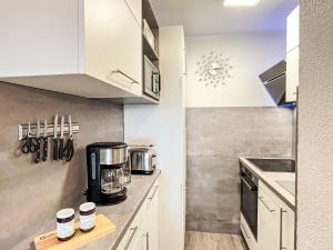 迪蒂斯豪森Apartment F 96 by Interhome的厨房配有白色橱柜和台面上的咖啡壶