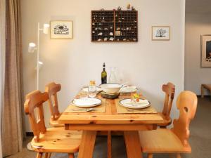 茨韦西门Apartment Chalet Simmental P-3 by Interhome的一张带两把椅子的木桌和一瓶葡萄酒