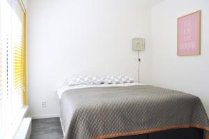 埃因霍温De Eindhovenaar City Apartments的一间卧室配有一张带灰色毯子的床