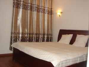 佛里茨道酒店餐厅的一间卧室配有一张带白色床单和窗帘的床
