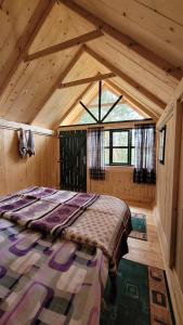 KosanicaEco Camp Drno Brdo的木制客房内的一间卧室,配有一张床