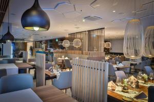 菲拉赫Hotel Seven的餐厅设有木桌和椅子及灯