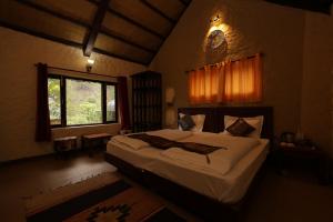 本贾尔Thehraav By The River - Tirthan的一间卧室设有一张大床和一个窗户。