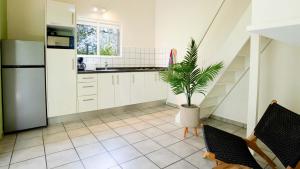 威利布罗德Dream of the Green Flamingo的厨房配有白色橱柜和盆栽植物