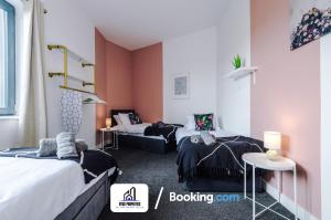 曼彻斯特Monthly Stays By NYOS PROPERTIES Short Lets & Serviced Accommodation Manchester Business Leisure的一间客房配有两张床和一张沙发
