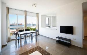 格拉德卡斯特利翁滨海套房公寓的客厅配有桌椅和电视。