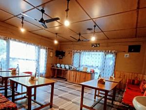 本贾尔Sharda Resort-Tirthan Valley的客厅配有两张桌子和一张沙发