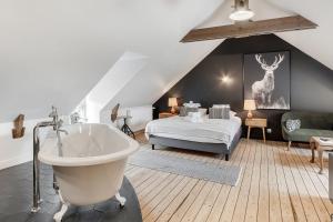 康卡勒LE ROCHER- Belle maison de charme -Jardin/Parking的卧室配有床和浴缸