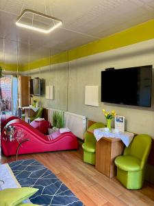 格涅兹诺Apartament "Love Island" z Jacuzzi SPA dla Dwojga的客厅配有色彩缤纷的家具和平面电视。