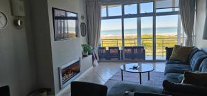 开普敦Beachfront 3-bedroom with Robben Island views的一间带壁炉的客厅,享有海景