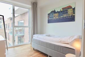 哥本哈根Modern 2-bed wbalcony in Ørestaden的一间卧室设有一张床和一个大窗户