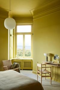 汉堡stilwerk Strandhotel Blankenese的一间卧室配有一张床、一张书桌和一个窗户。
