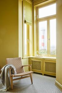 汉堡stilwerk Strandhotel Blankenese的一间带椅子的浴室和一个带灯塔的窗户