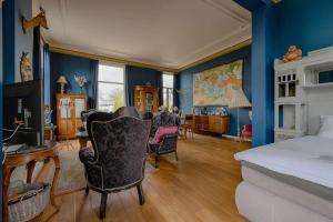 费尔普Villa Dalenstein的卧室拥有蓝色的墙壁,配有一张床和椅子