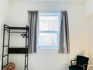 巴里Leah Suite by Koya Homes的客房设有窗户、椅子和床。