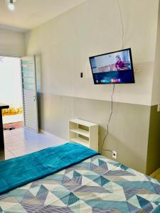 戈亚尼亚Casa da Vó Maria! Studio 08的卧室配有一张壁挂式平面电视的床。
