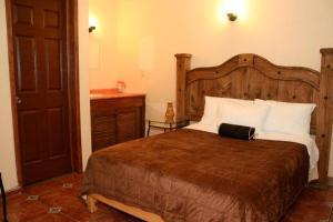 OcotlánHotel Posada Santa Fe的一间卧室设有一张大床和一个水槽